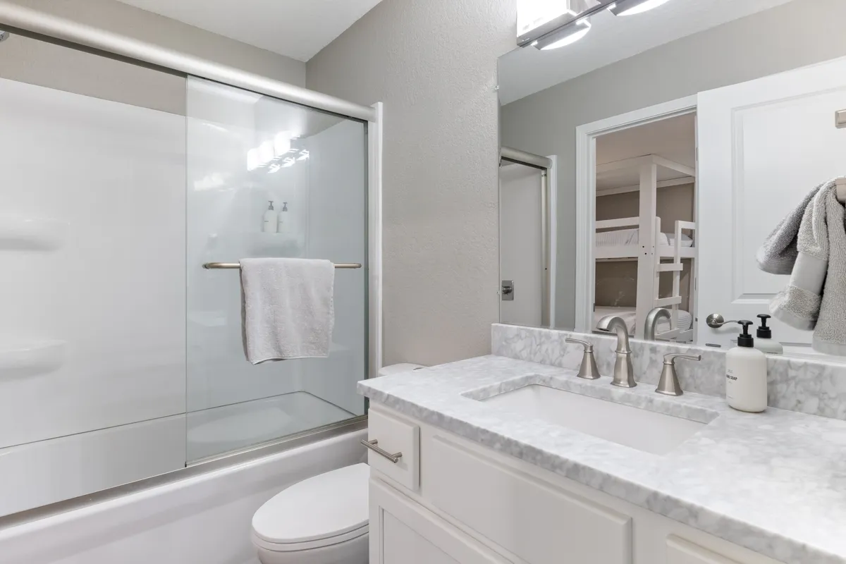 A modern, well-appointed bathroom featuring a double vanity with sleek sinks, a glass shower enclosure, and stylish fixtures. The space exudes cleanliness and serenity, perfect for recharging after a day of adventure.